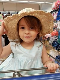 Close-up portrait of girl sitting in shopping cart