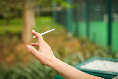Close-up of hand holding cigarette