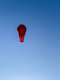 Low angle view of hot air balloons against clear blue sky