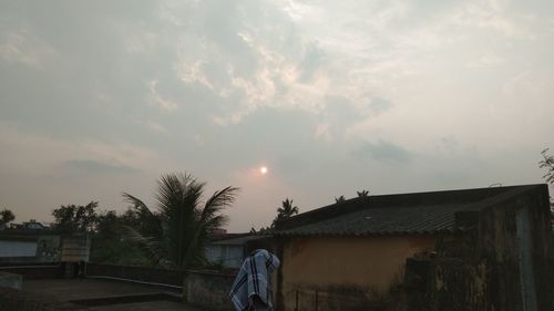 Houses and trees against sky at dusk