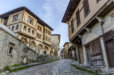 Alley amidst residential buildings against sky