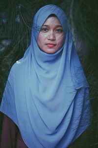 Portrait of woman wearing hijab by branch