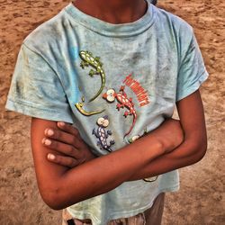 Midsection of boy standing with arms crossed