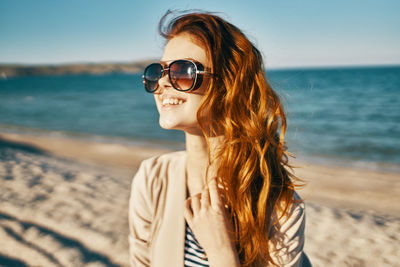 Portrait of young woman wearing sunglasses on beach