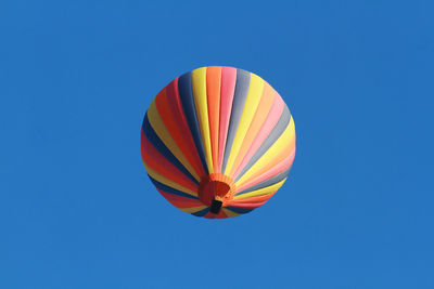 Low angle view of hot air balloon against clear blue sky