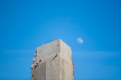 Low angle view of stone wall against blue sky