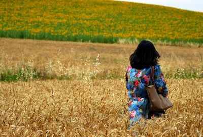 Rear view of woman standing on field