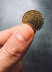 Close-up of hand holding coin against blurred background