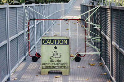 Information sign by fence on road