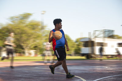 Portrait of basketball player running with the ball