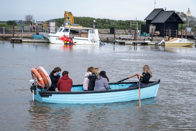 People on boat in lake against sky