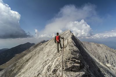 Panoramic view of person on rock against sky