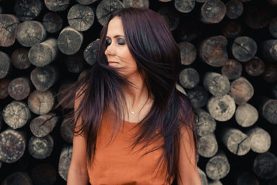 Portrait of woman standing on wooden logs