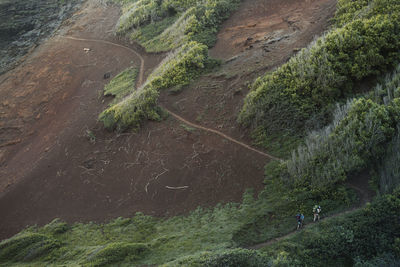 High angle view of hikers walking on mountain 
