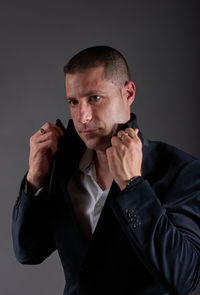 Young man looking away against black background