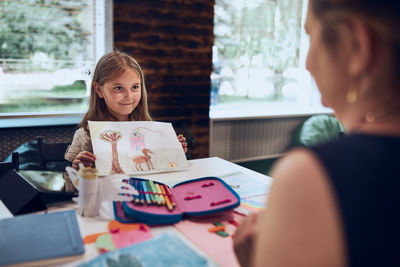 Portrait of young woman using digital tablet while sitting at home