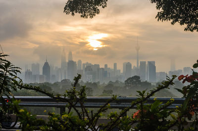 Buildings in city against cloudy sky