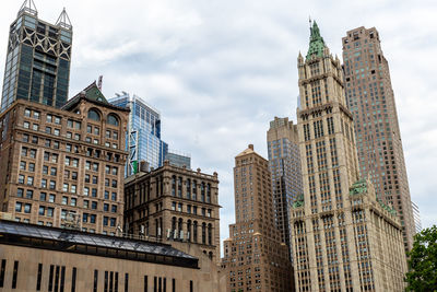 Low angle view of buildings against cloudy sky