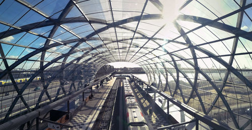 Railroad tracks in modern tunnel against sky