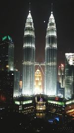 Illuminated cityscape against sky at night