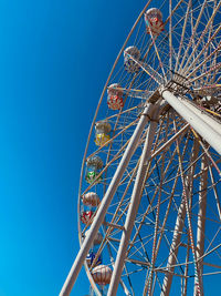 Low angle view of ferris wheel against blue sky