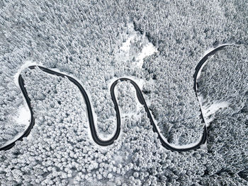 Aerial view of road amidst snow covered trees