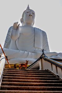 Low angle view of statue against temple against sky