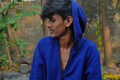 Young man wearing hooded shirt looking away