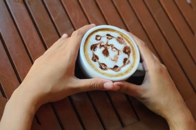 Cropped image of hand holding coffee cup