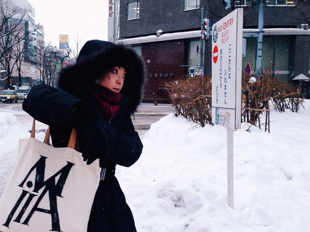 snow, winter, cold temperature, season, weather, lifestyles, warm clothing, person, young adult, portrait, leisure activity, front view, building exterior, looking at camera, standing, covering, jacket, young women