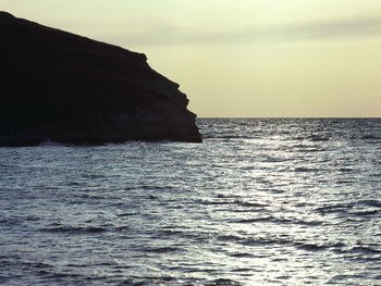 Rock formation in sea against sky