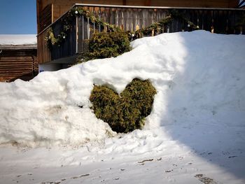 Snow on house against sky during winter