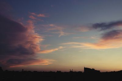 Silhouette cityscape against sky at sunset