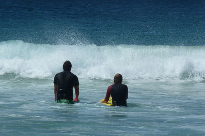 Man and woman bodysurfing at the beach