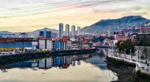 Reflection of buildings in river against sky