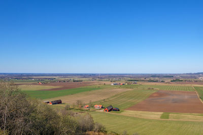Scenic view of agricultural field against clear blue sky