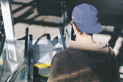 Rear view of man on escalator