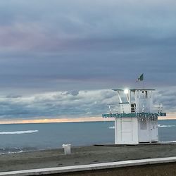 Lifeguard hut by sea against sky