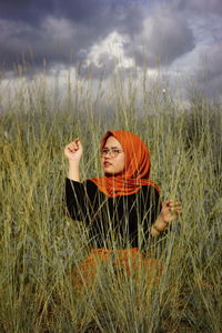 Woman relaxing on field against sky