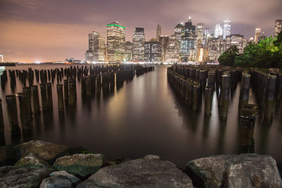 River amidst illuminated buildings against sky at night