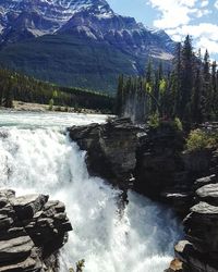 Scenic view of waterfall against sky