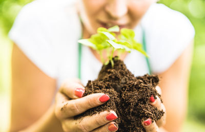 Close-up of woman holding plant