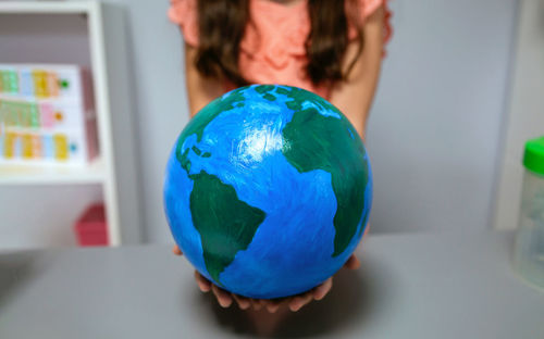 Midsection of woman holding globe