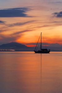 Silhouette sailboat on sea against sky during sunset