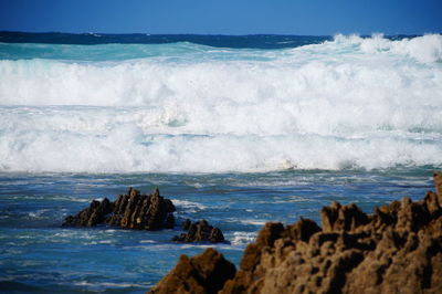 Scenic view of rocks in sea against sky