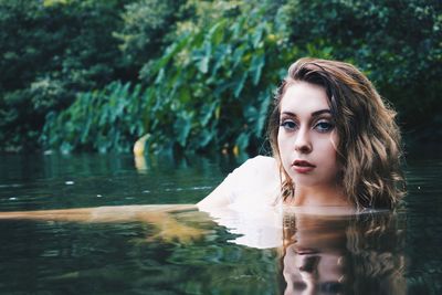 Portrait of young woman in lake