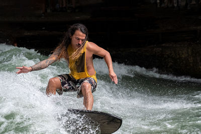 Full length of young woman splashing water