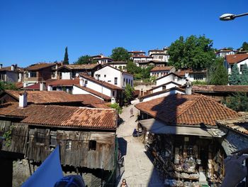 Houses in town against clear blue sky