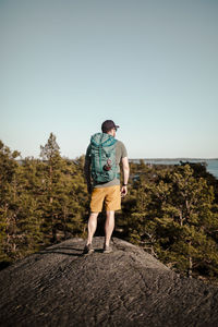 Rear view of man standing against clear sky