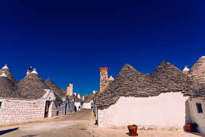 Buildings in city against clear blue sky